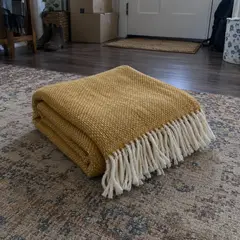 folded mustard woven blanket, as photographed