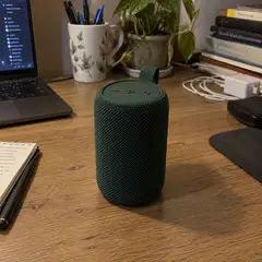 compact forest-green cylindrical portable speaker, as photographed