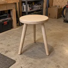 round pale wood stool, as photographed