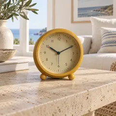 round ochre analog table clock on two small feet, moved into a new room