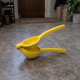 yellow handheld hinged citrus squeezer, as photographed