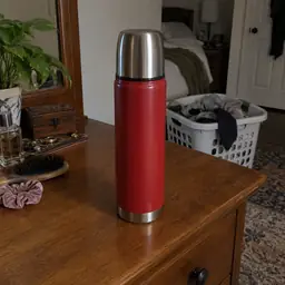 red cylindrical vacuum thermos, as photographed